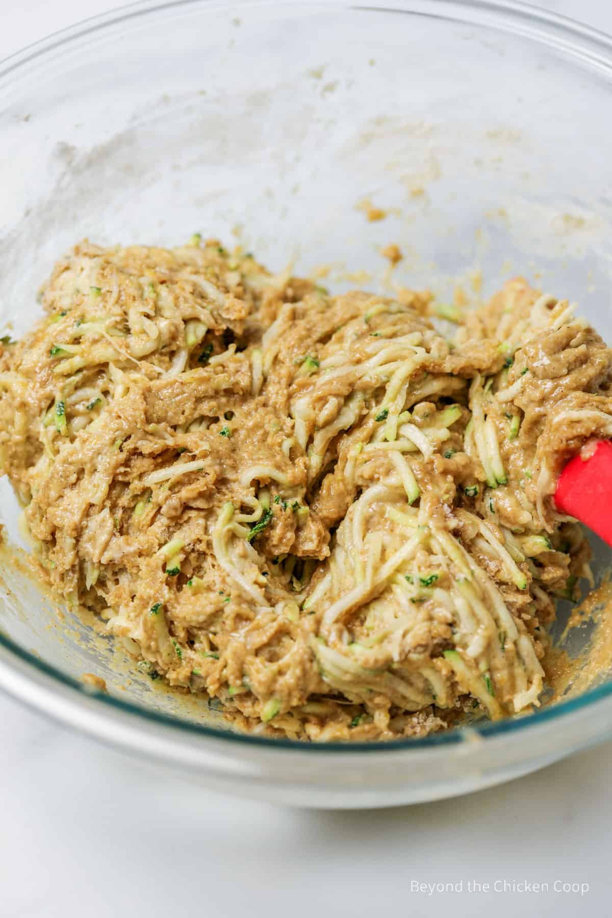 Zucchini bread batter in a large glass bowl.