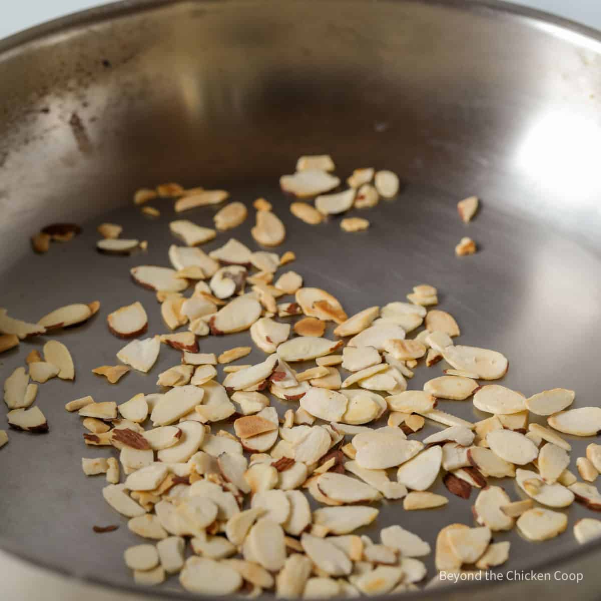 Browning almond slices in a dry pan.