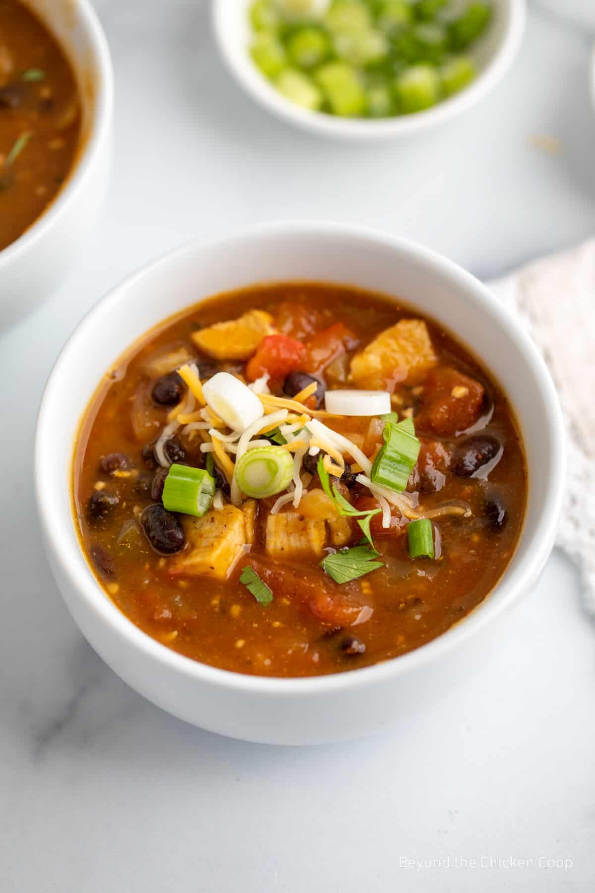 A white bowl filled with a black bean chili. 