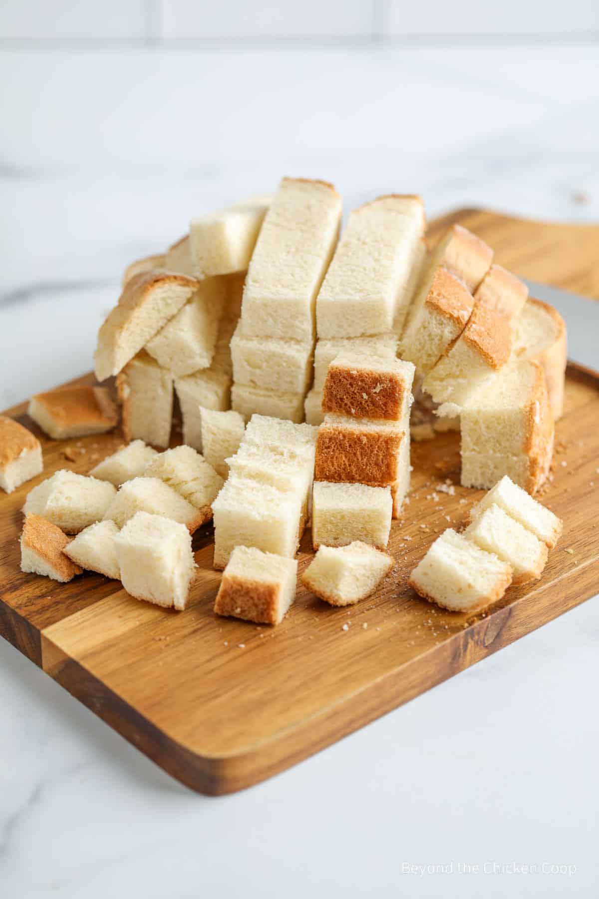 Cubes of cut bread on a cutting board. 