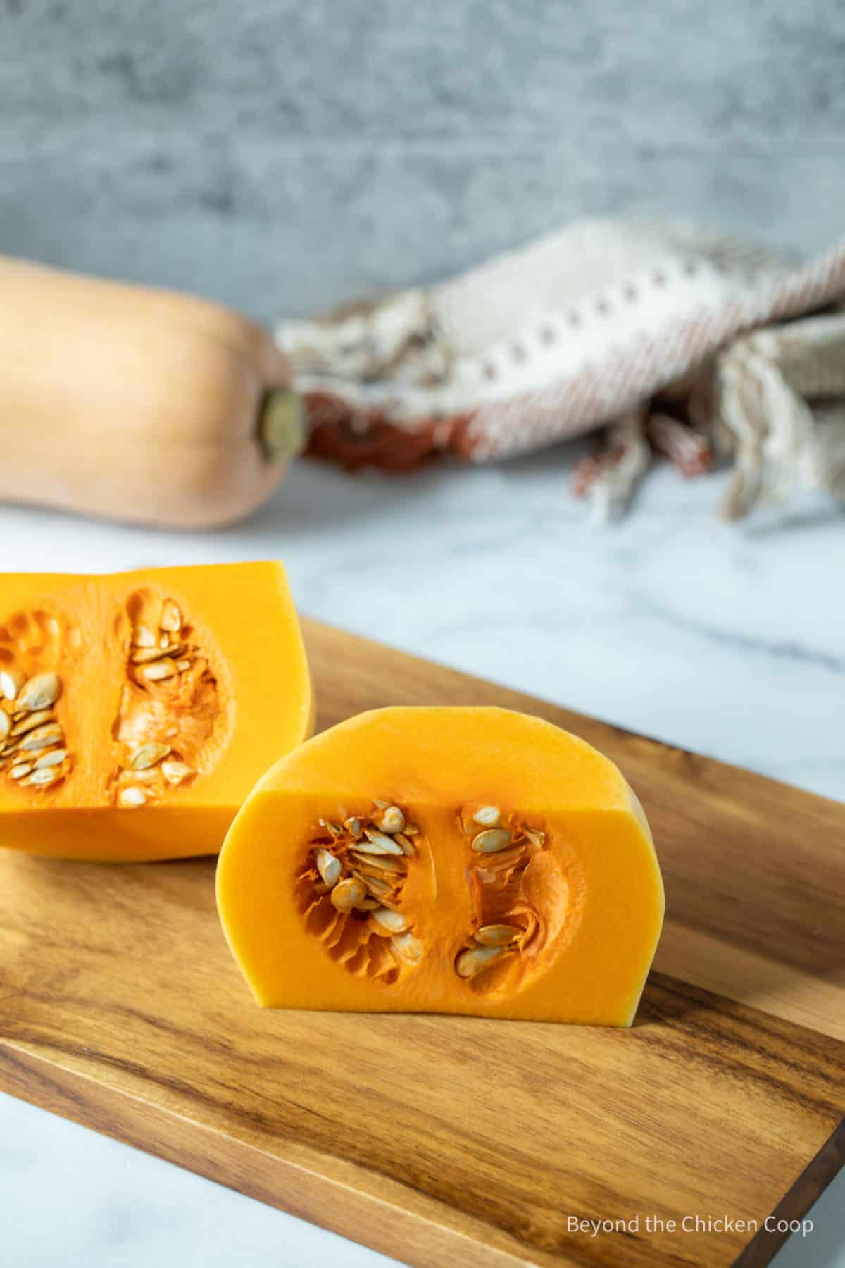 The bottom half of a butternut squash cut in half with the seeds showing. 