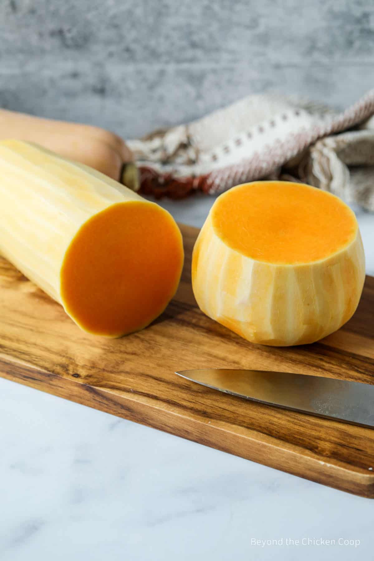 A squash cut in half on a cutting board.