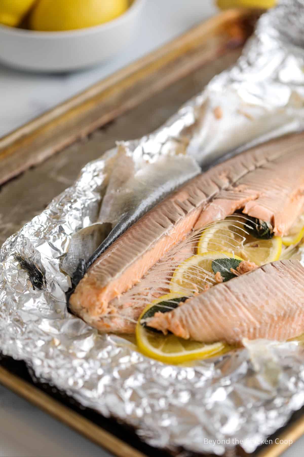 Removing fillets of trout from a whole baked fish. 