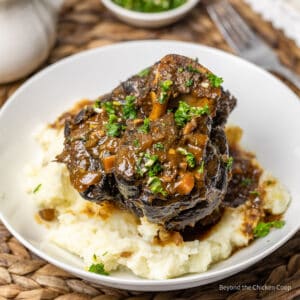 Elk shanks with a rich sauce on a bed of mashed potatoes.