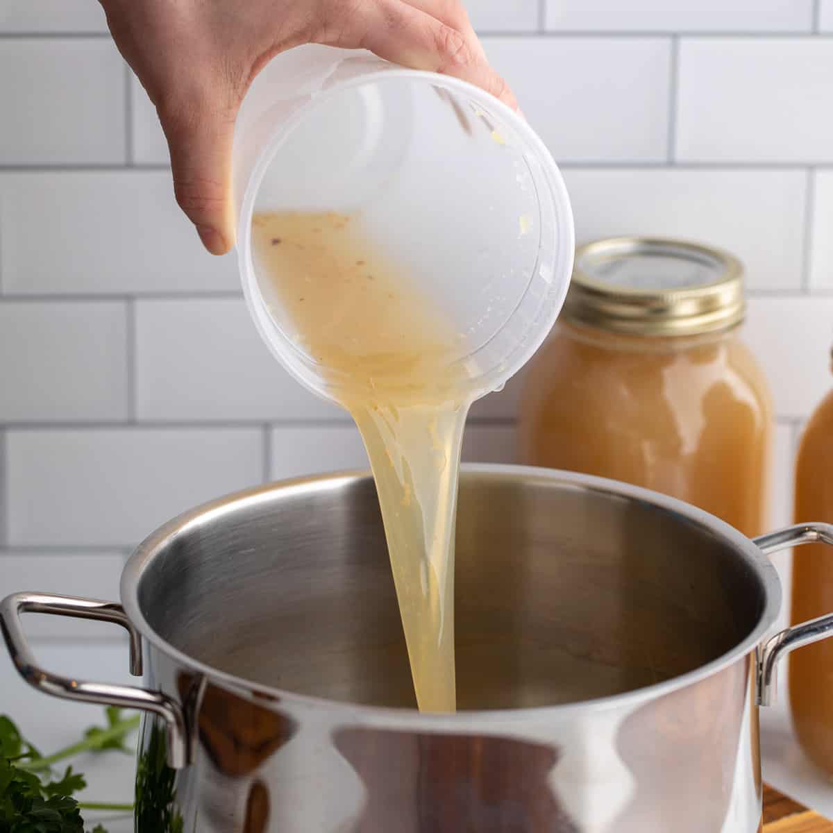 Pouring turkey broth into a stock pot. 