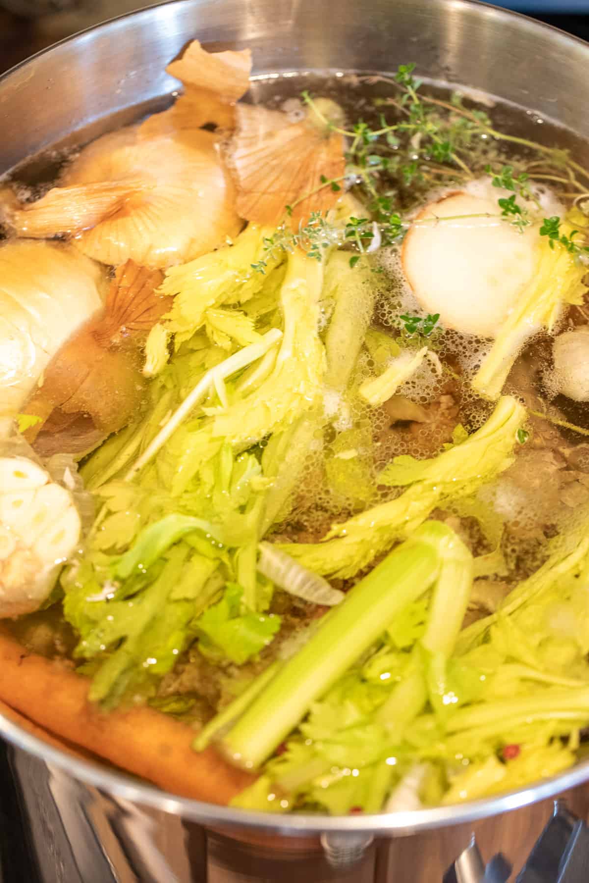 A stockpot filled with celery, onions and bones.