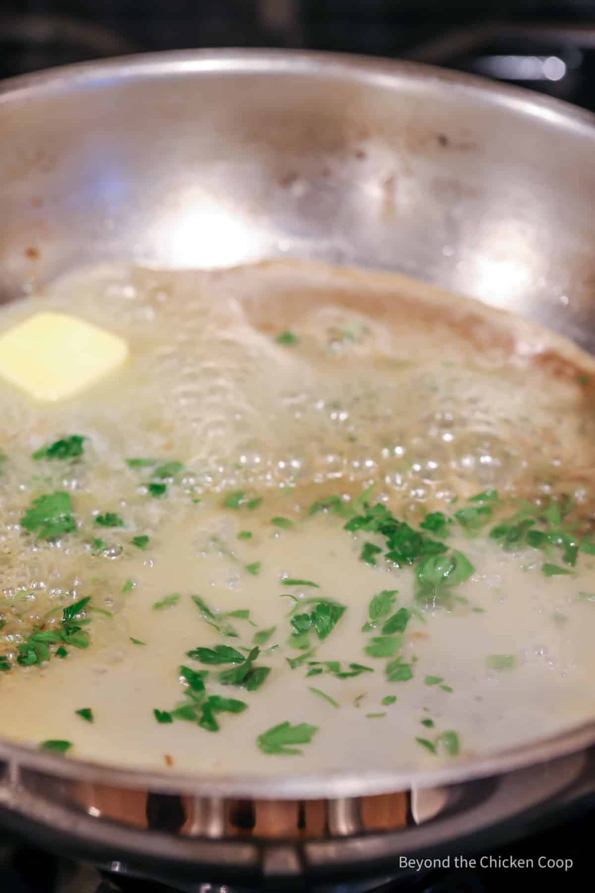 Butter melting in a pan with lemon juice and parsley.