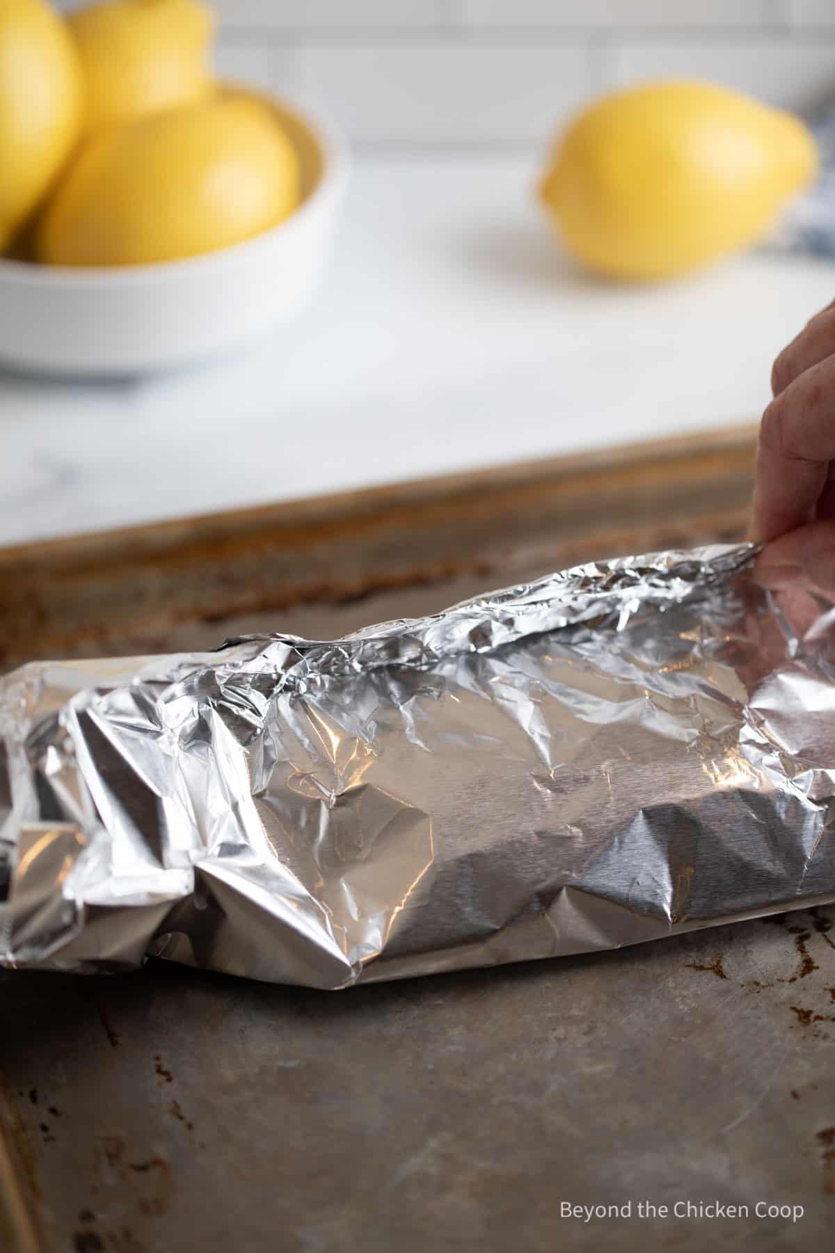 A foil packet on a baking sheet. 