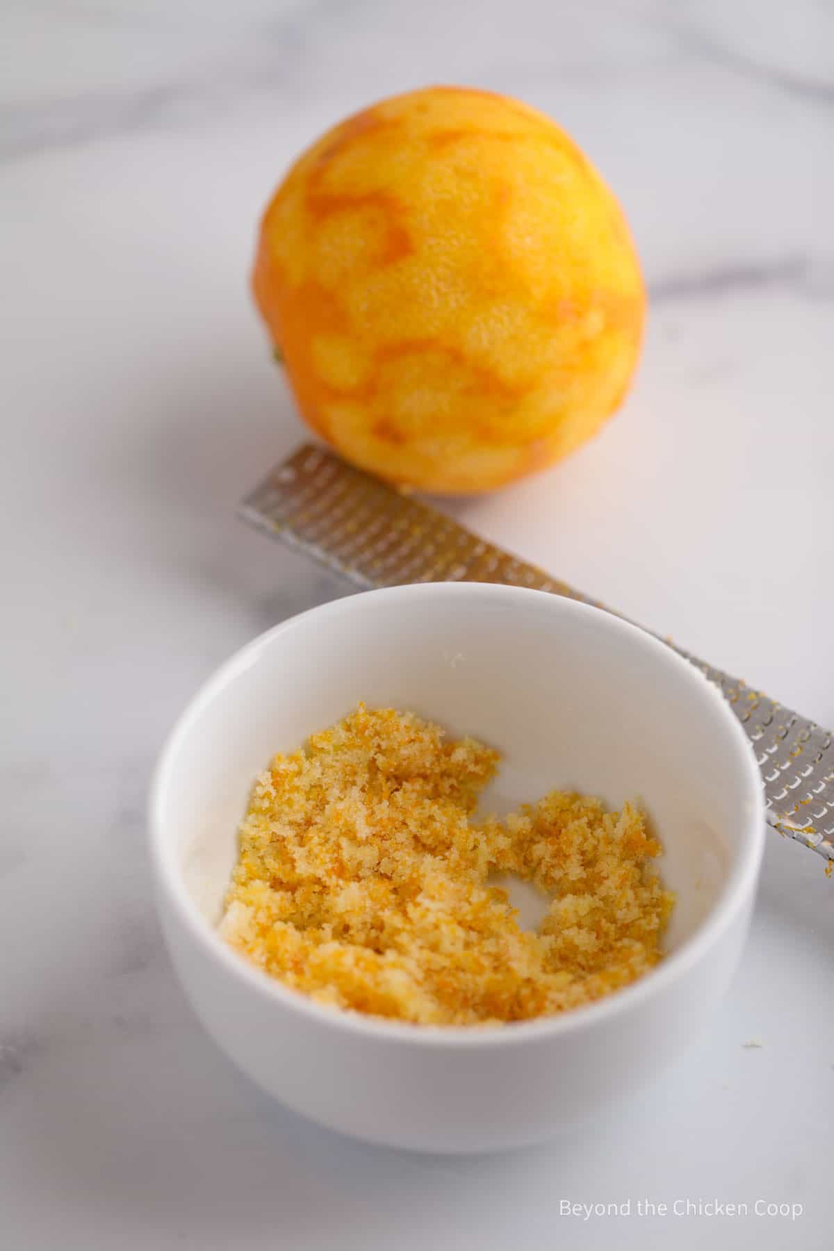 Orange sugar in a white bowl.