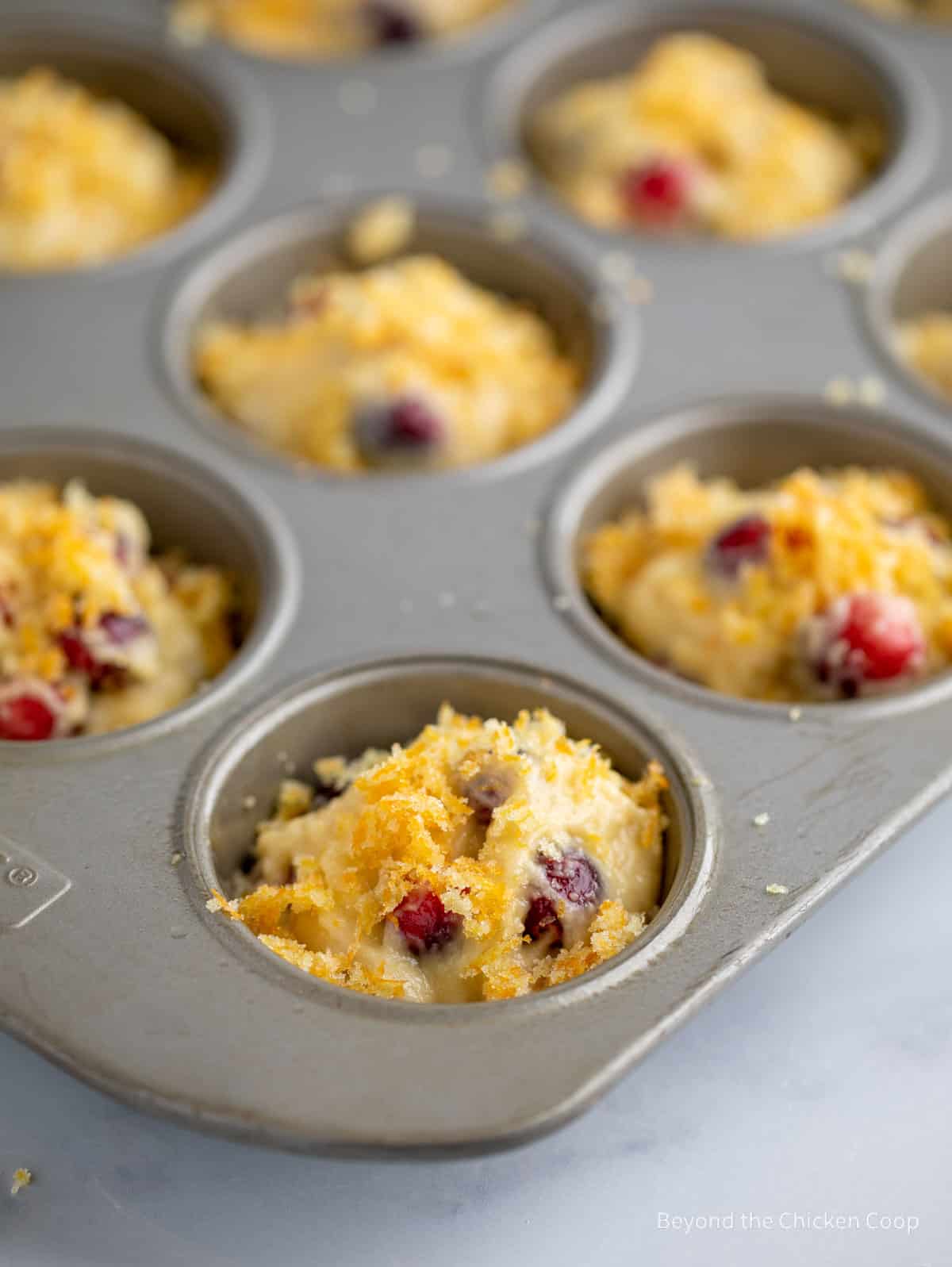 Muffin batter topped with a sugar sprinkle.