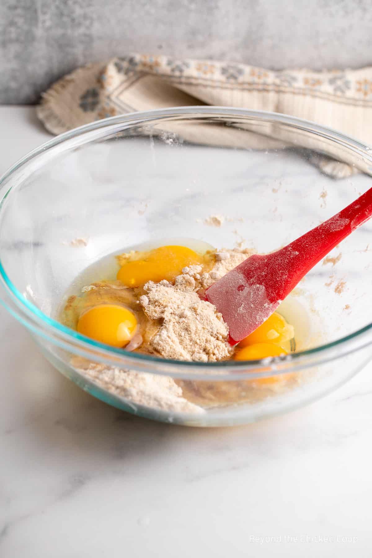 Mixing eggs with flour in a bowl.