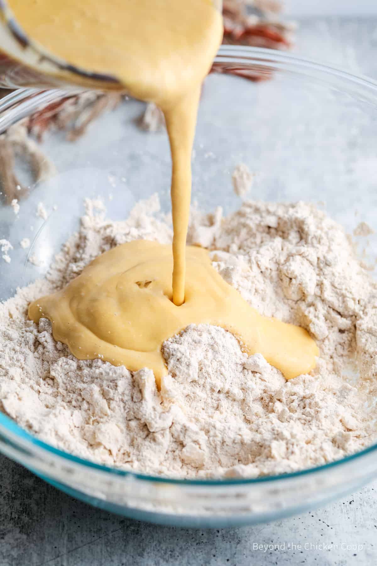 Pouring liquid into a flour mixture.