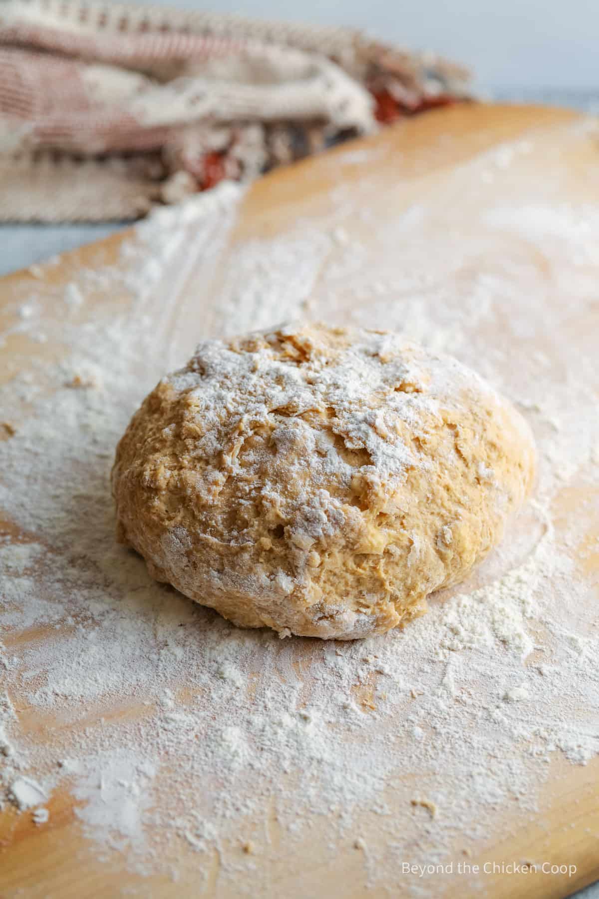 A ball of dough on a floured board.