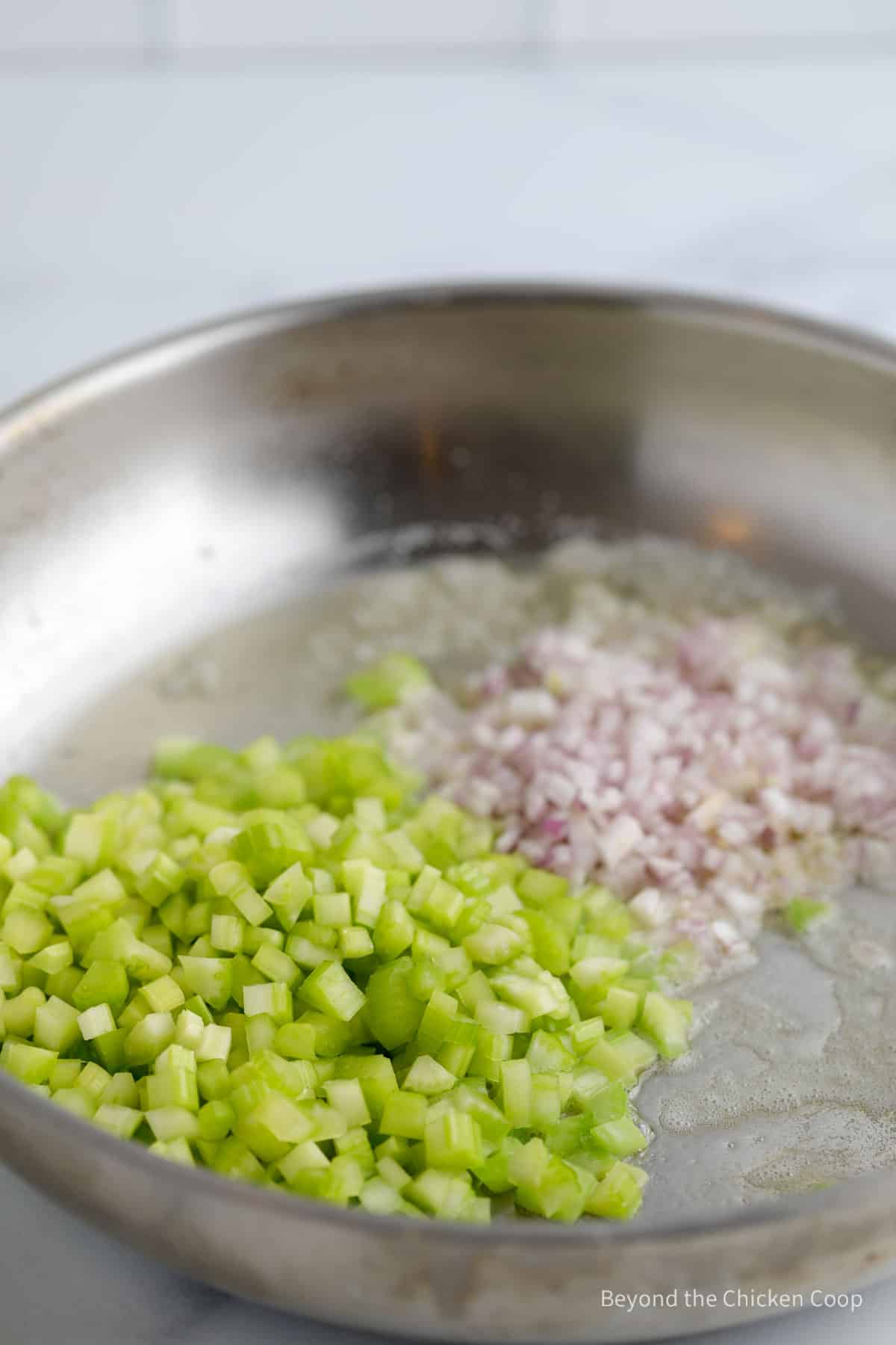 Celery and shallots in a large pan.