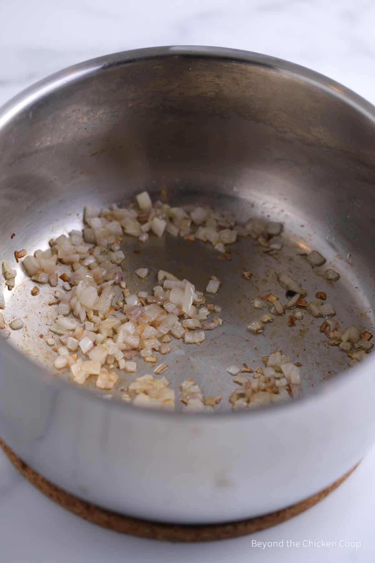 Cooking shallots in a saucepan.
