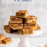Pecan squares stacked on a white pedastal stand.
