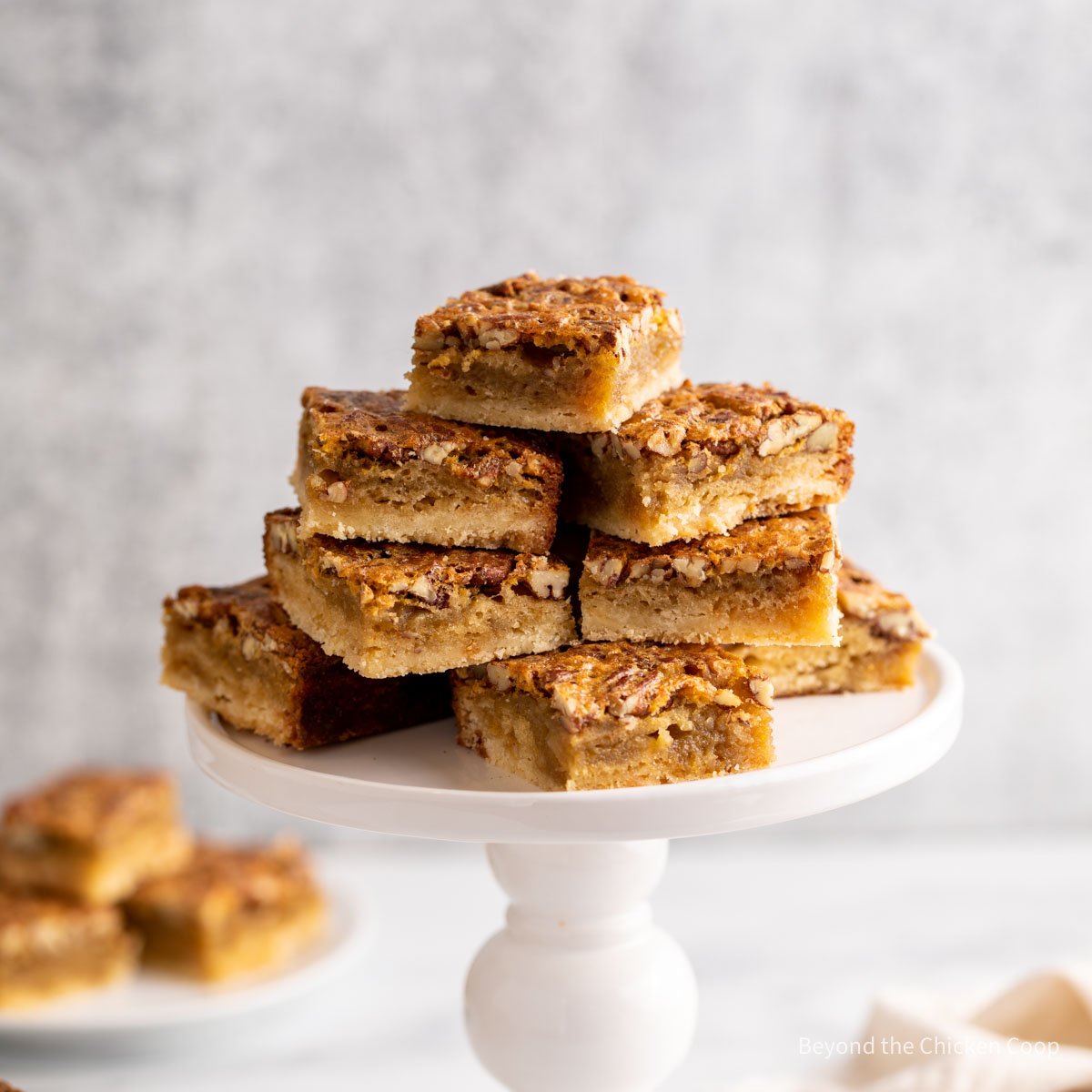 A cake stand filled with pecan bar squares.