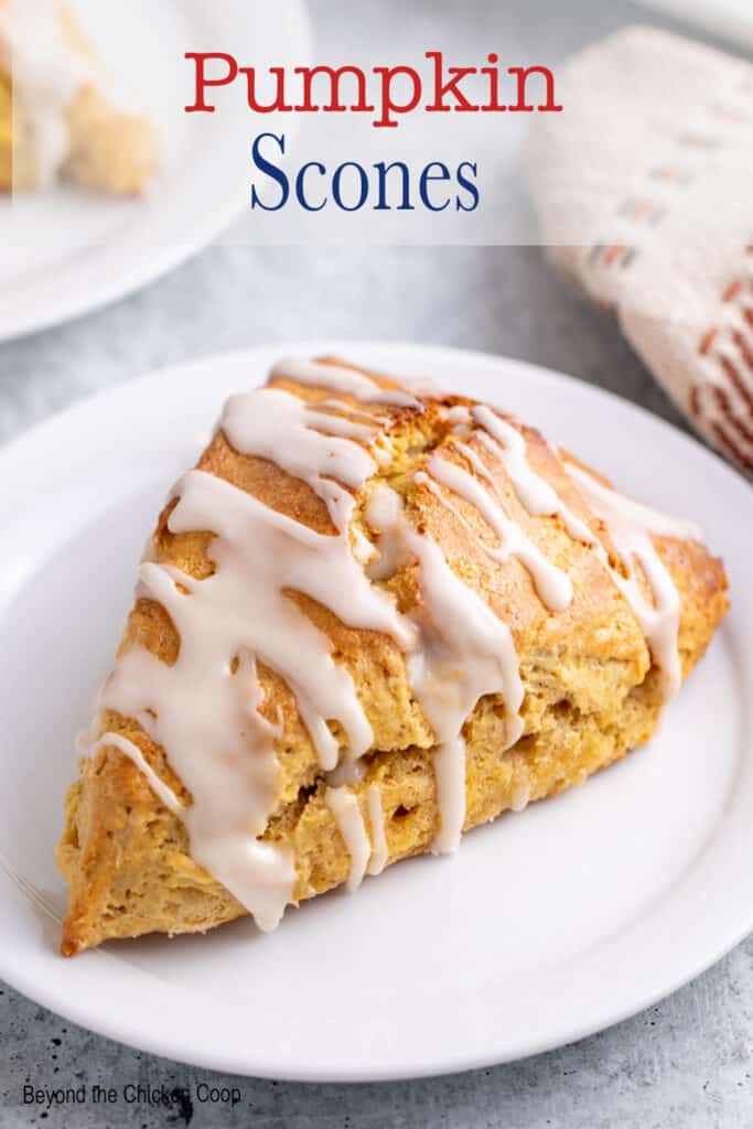 A glazed scone on a white plate.