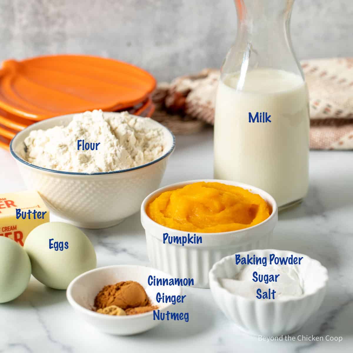 Small bowls filled with ingredients for making pumpkin waffles. 