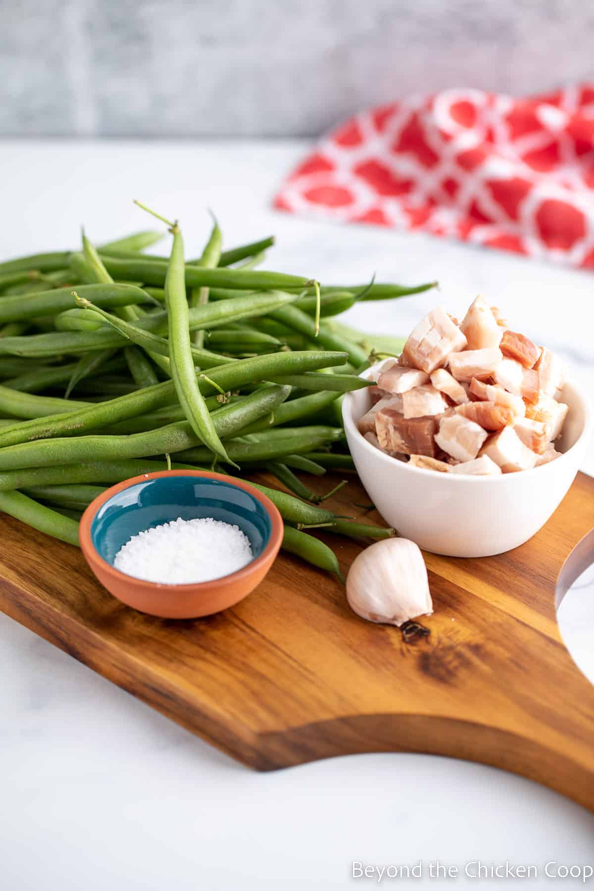 Green beans, bacon and garlic on a cutting board. 