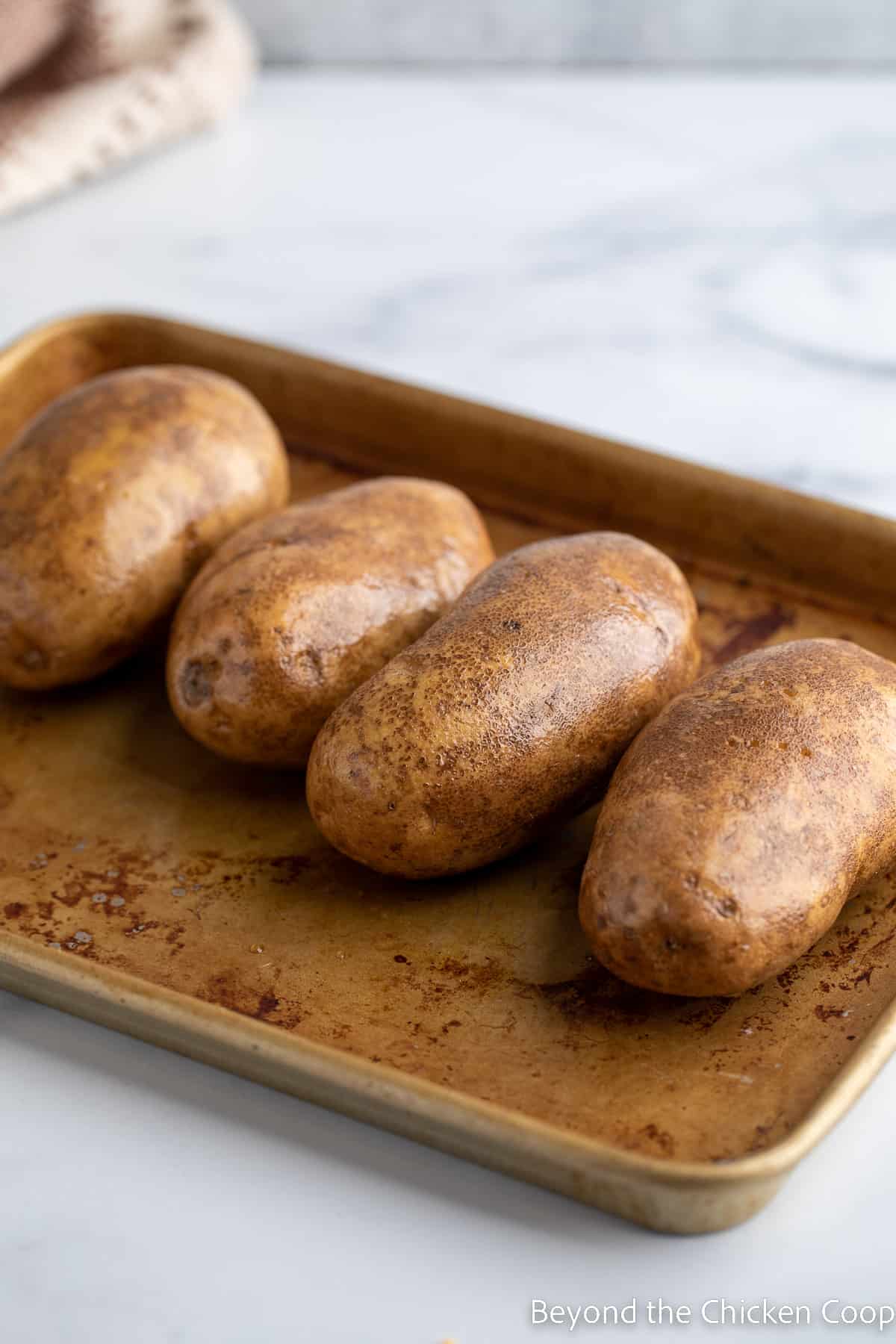 Russet potatoes on a cookie sheet.