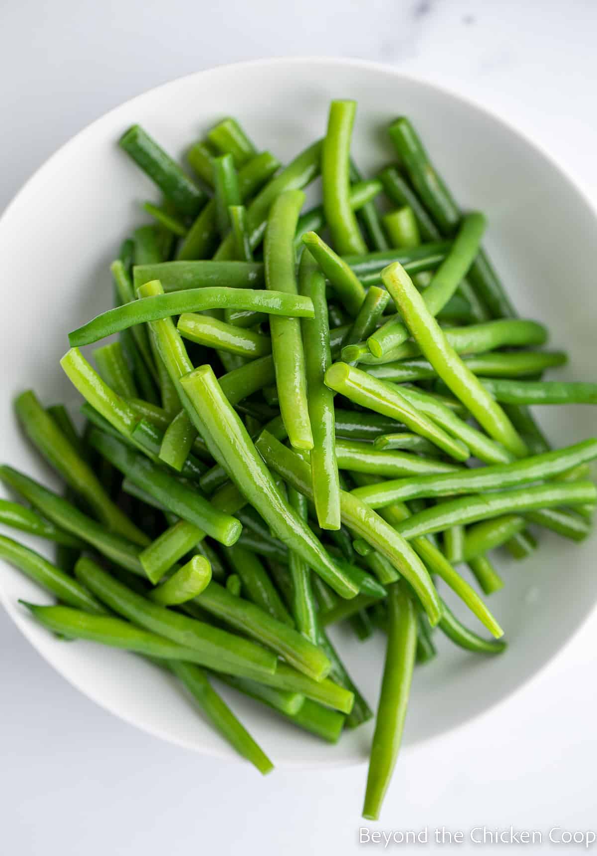 Green beans in a white bowl. 