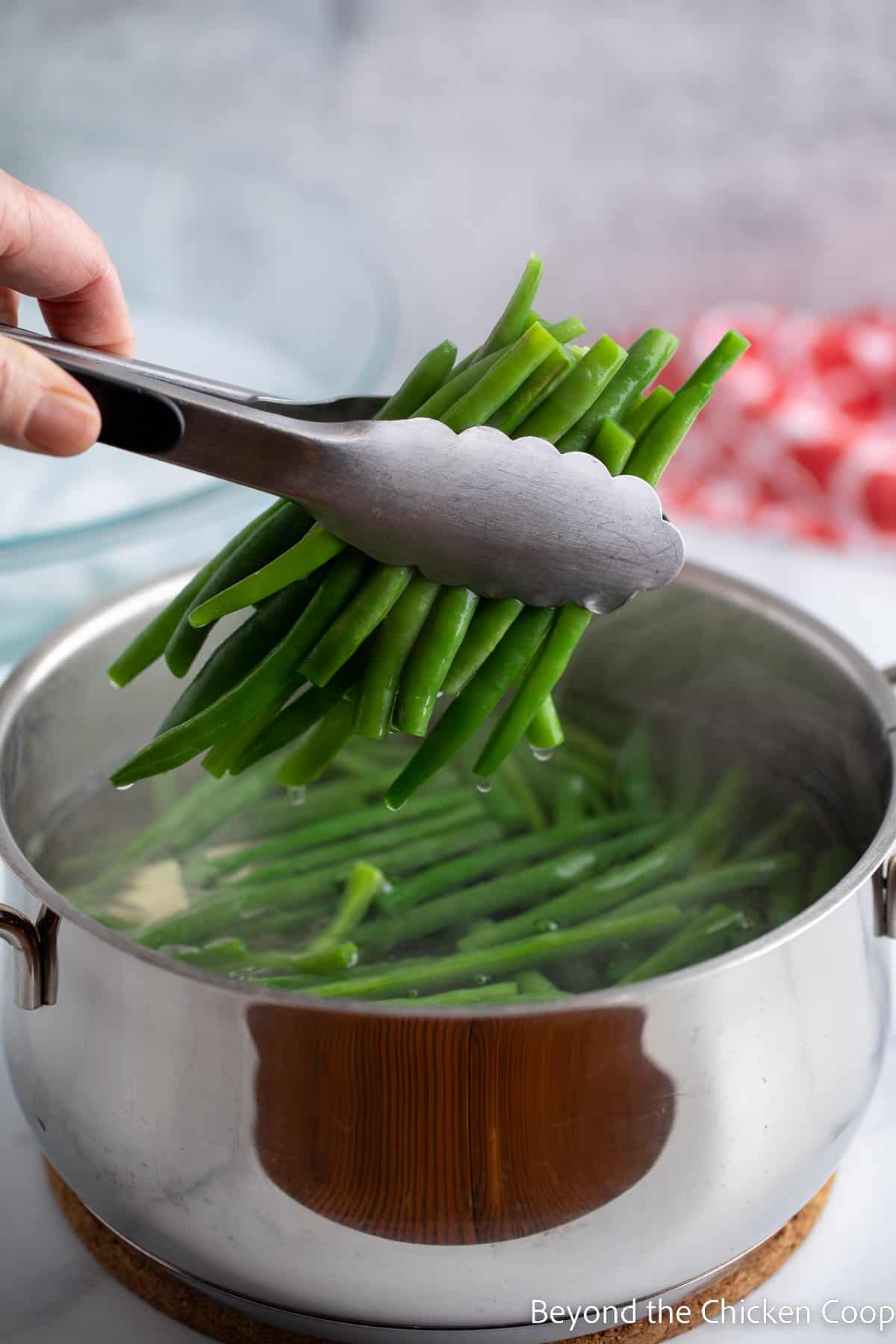Removing green beans from boiling water.