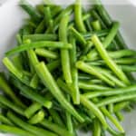 Bright green beans in a white bowl.