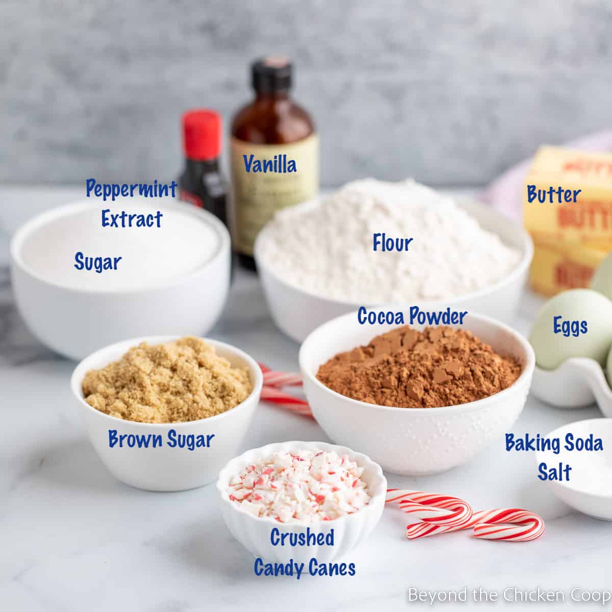 Small white bowls filled with different ingredients for making cookies. 