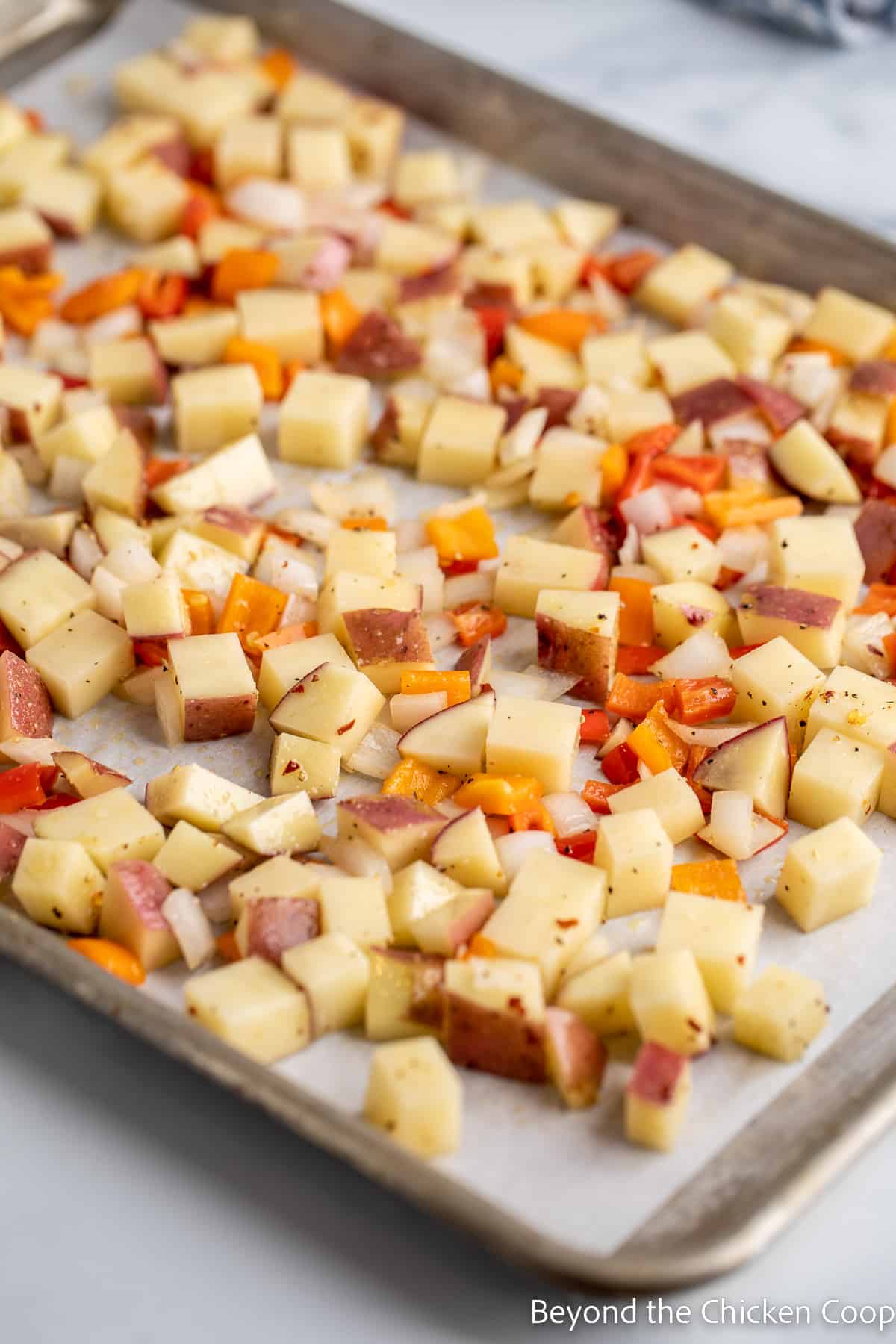 Cubed potatoes on a baking sheet.