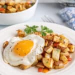 A fried egg over breakfast potatoes.