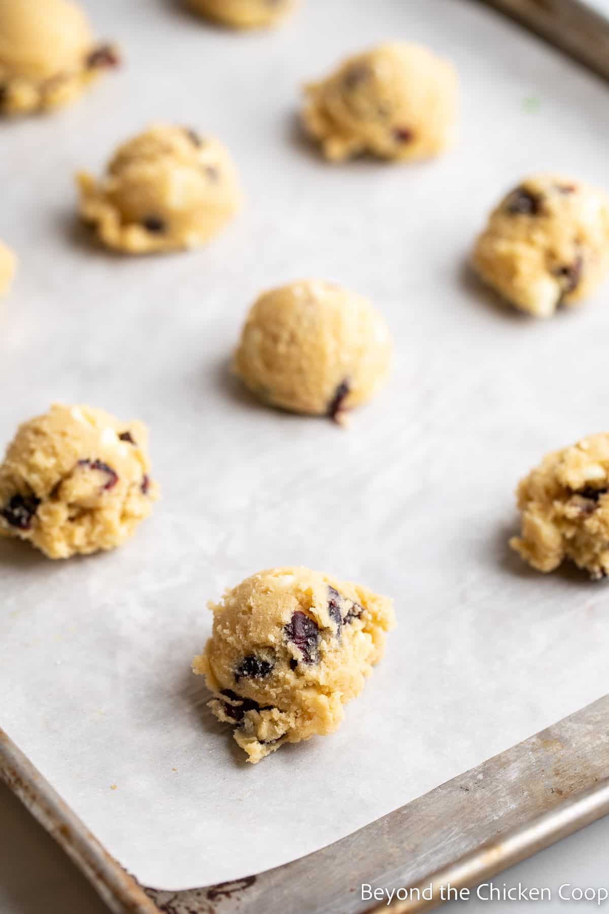 Balls of cookie dough on a baking sheet.