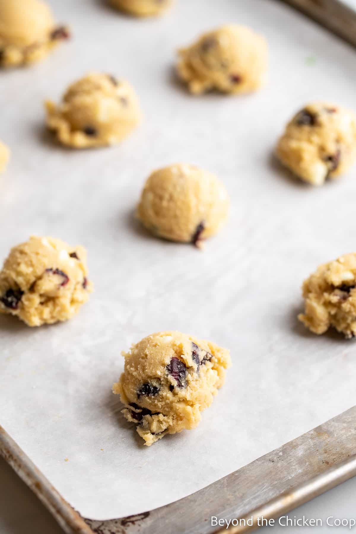 Balls of cookie dough on a baking sheet. 