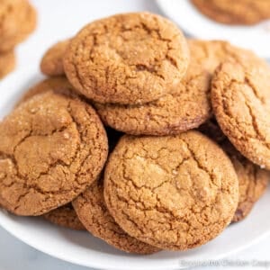 Round brown cookies on a white plate.