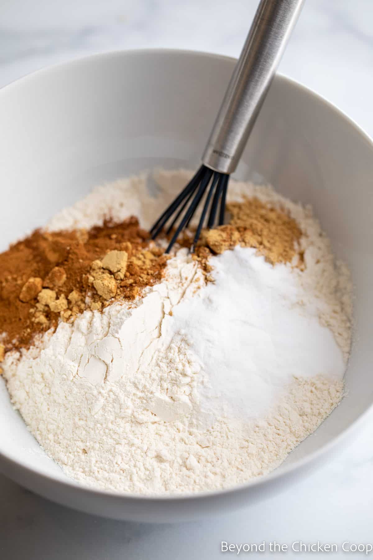 Mixing flour with spices in a bowl.