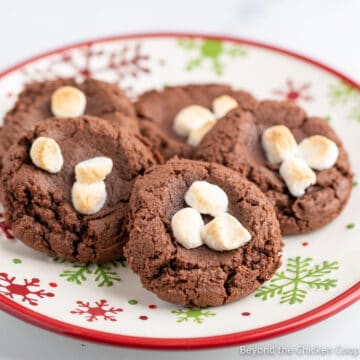 A plate filled with chocolate cookies topped with marshmallows.