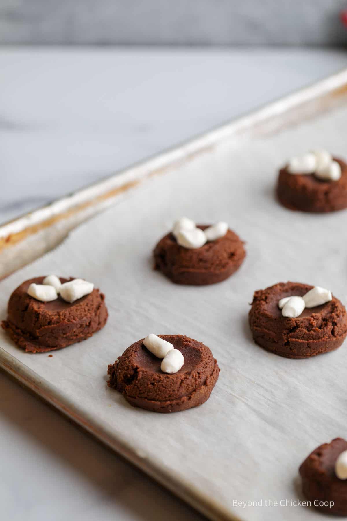 Unbaked cookies topped with marshmallows.