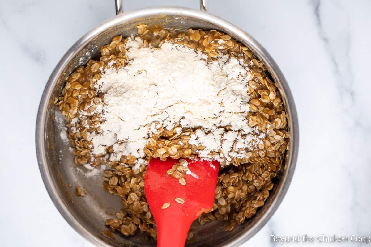 Adding flour to oatmeal cookie batter.