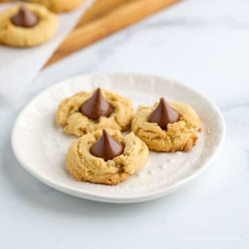 Three cookies with chocolate kisses on a plate.