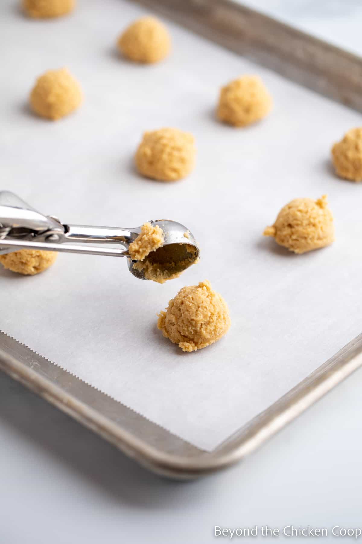 ScAdding cookie dough onto a baking sheet. 