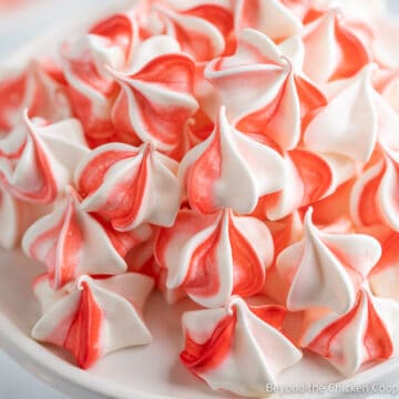 A plate filled with red and white meringues.