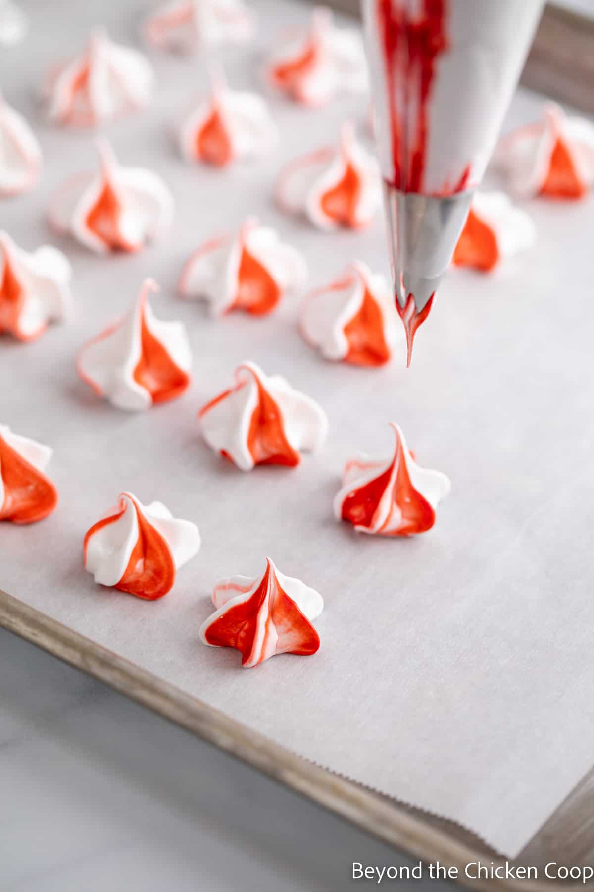 Red and white meringues on a baking sheet.