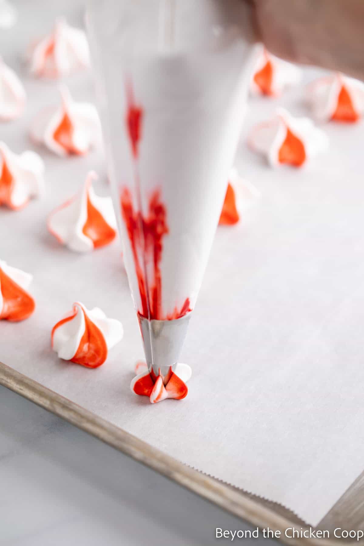 Piping a meringue kiss onto a baking sheet. 