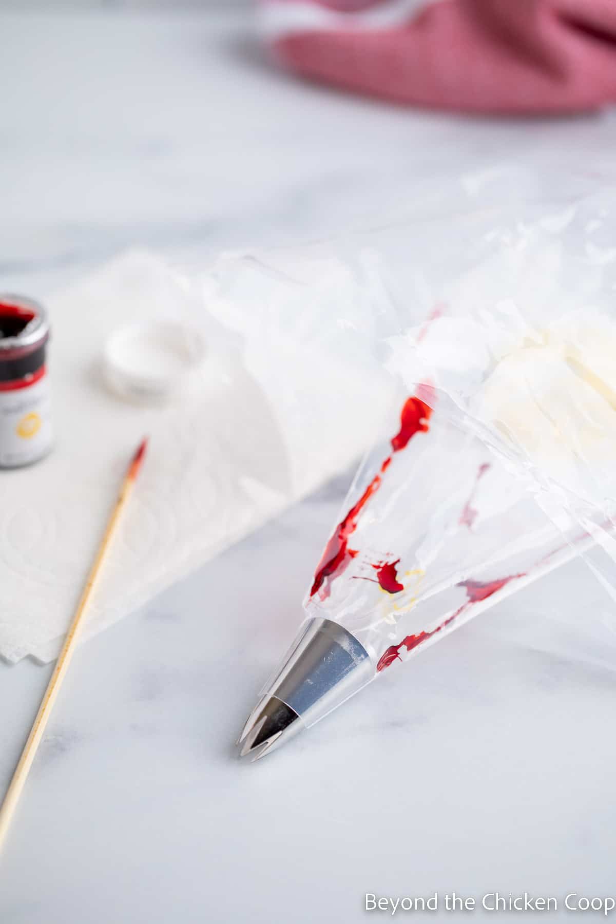 Lining a pastry bag with red food coloring.