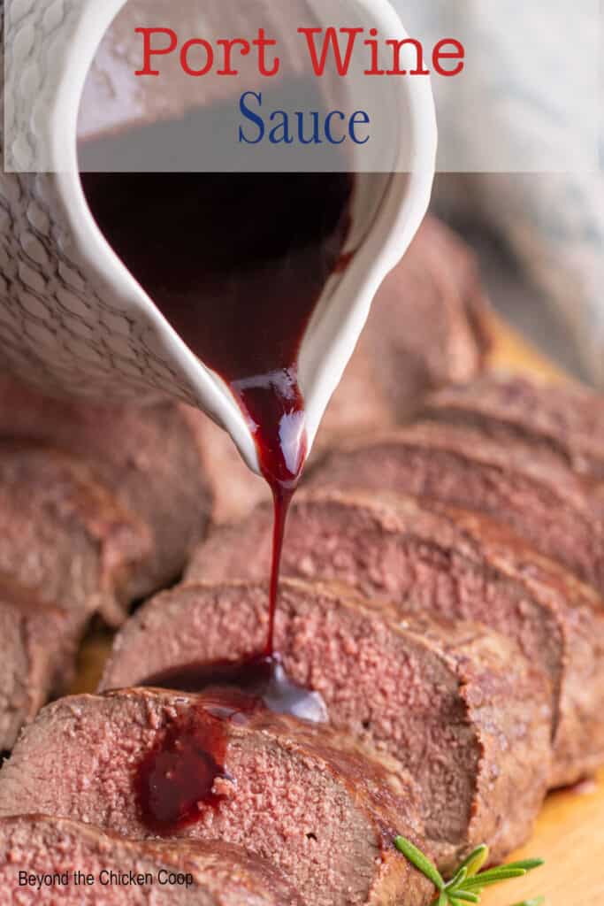 A red wine sauce being poured over sliced meat.