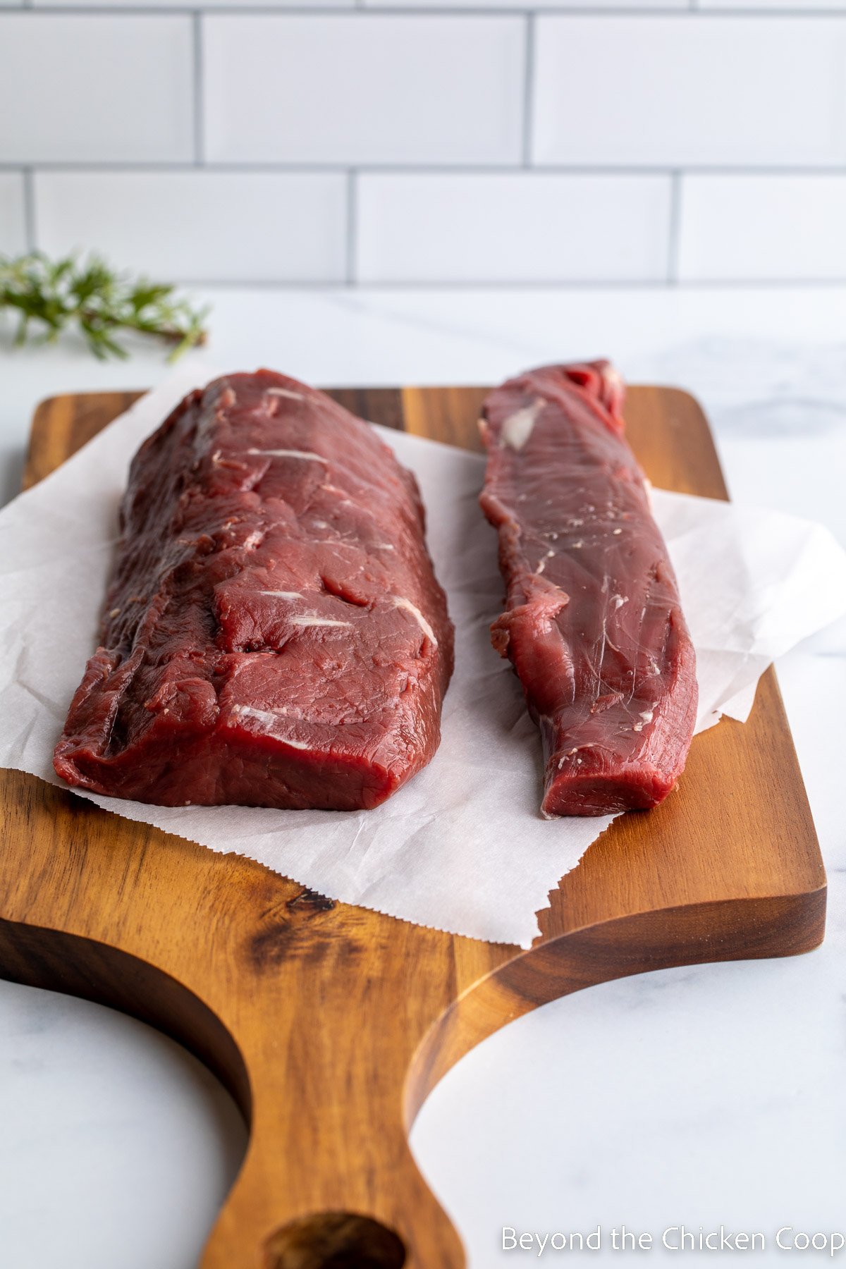 Backstrap and a tenderloin on a cutting board. 