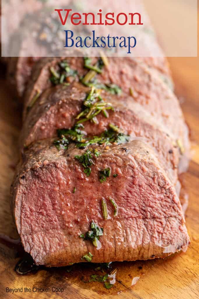 Sliced venison topped with butter and herbs.