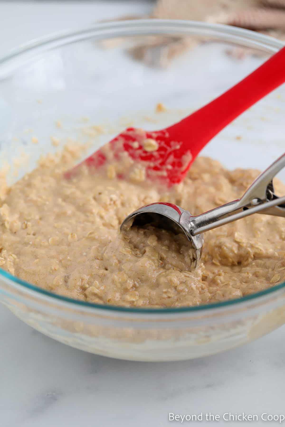 Scooping batter with an ice cream scoop. 