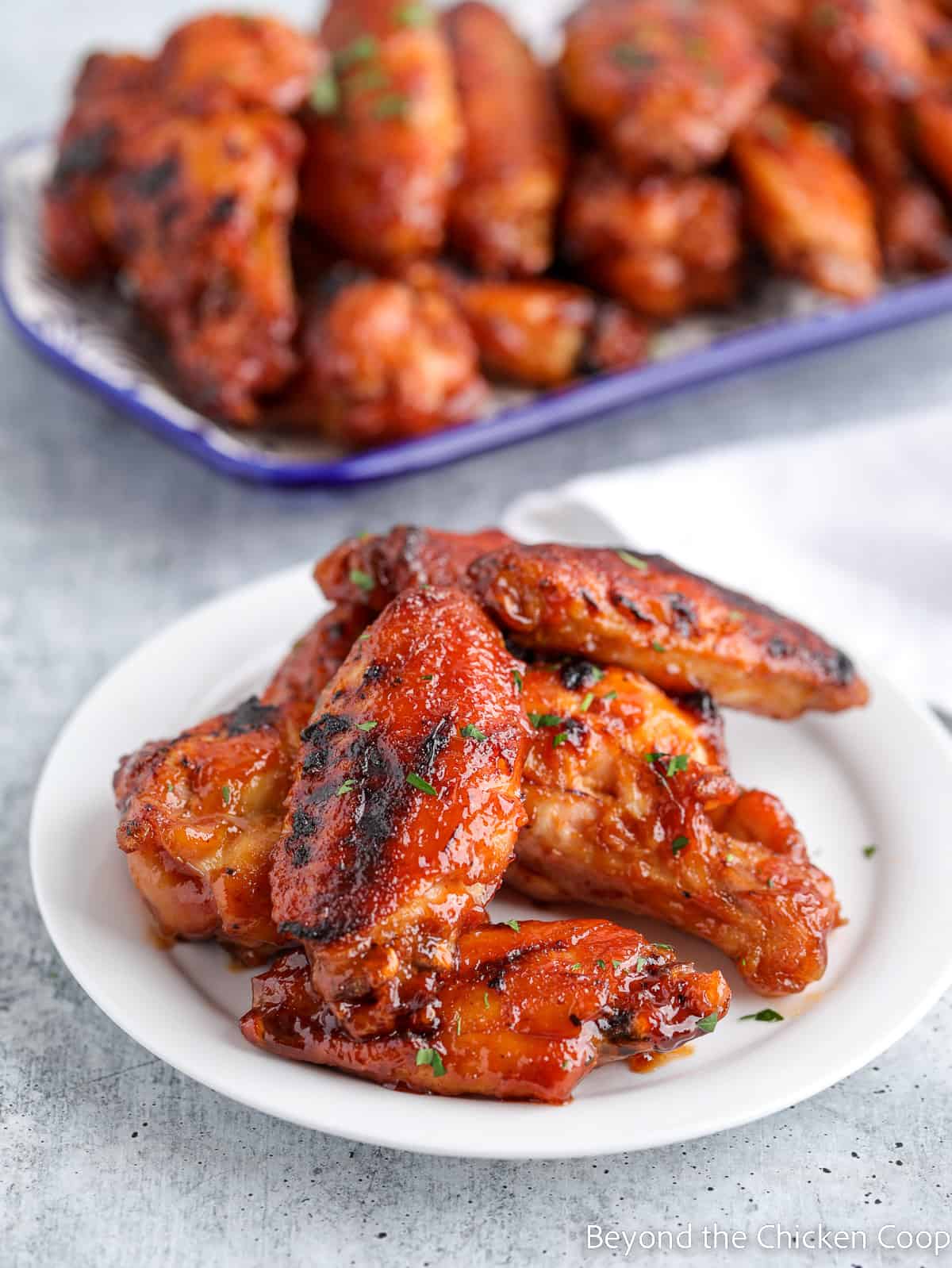 Chicken wings with sauce on a white plate. 