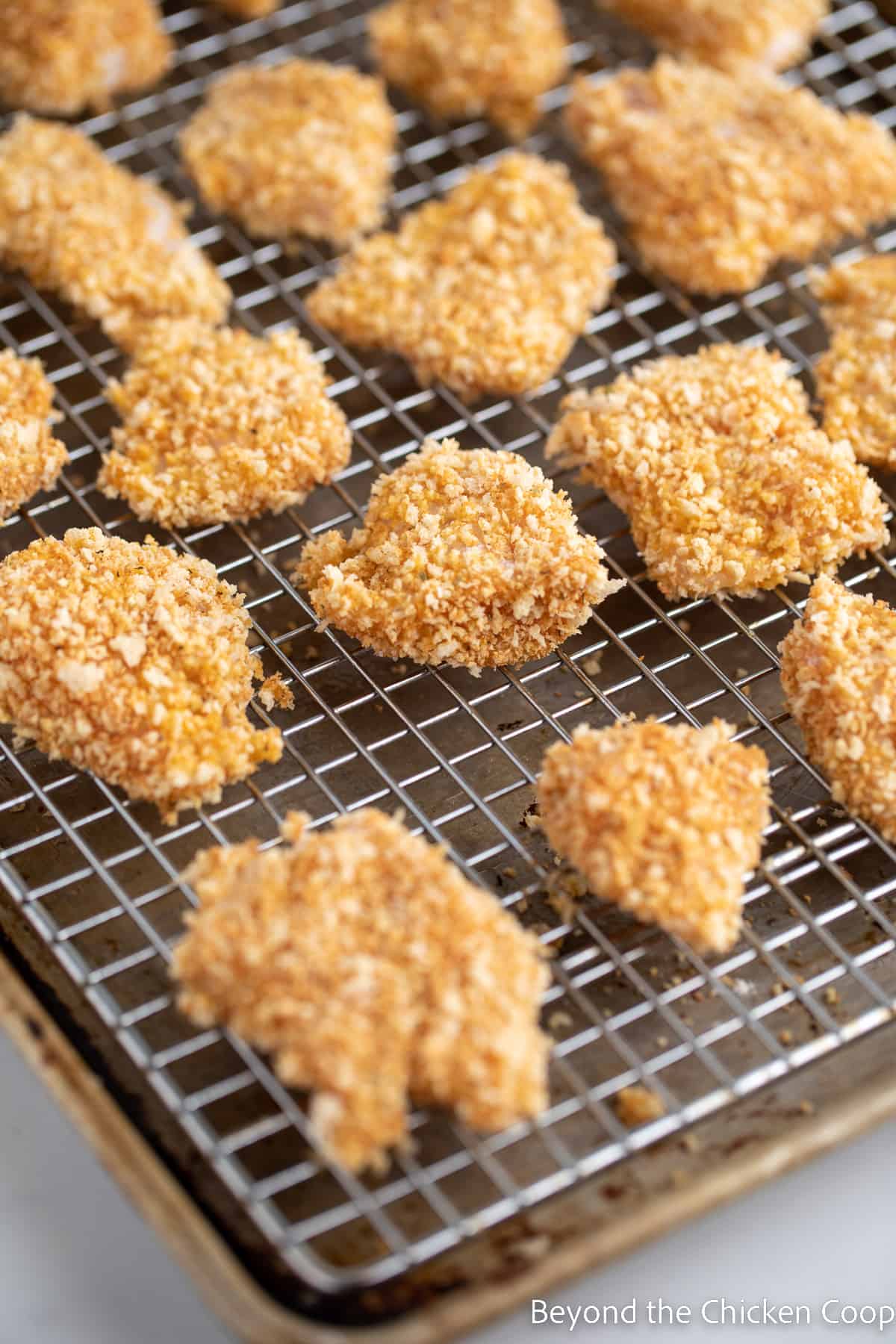 Unbaked chicken nuggets on a baking rack. 